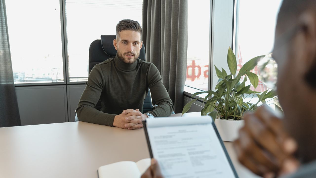 Equipe diversa reunida em uma mesa de escritório contemporâneo